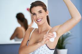 Mujer aplicando desodorante.